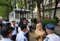 Camat Ujung Pandang, Nanin Sudiar berbincang dengan petugas Dinas Perhubungan sebelum penertiban parkir liar di Jalan Penghibur,  Selasa, (31/3/2026).